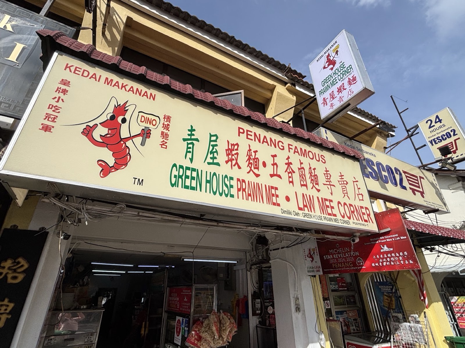 The cream Green House Prawn Mee, Law Mee Corner shopfront signboard with the red cartoon prawn mascot and a Michelin sticker